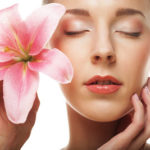 Beauty face of the young woman with pink lily