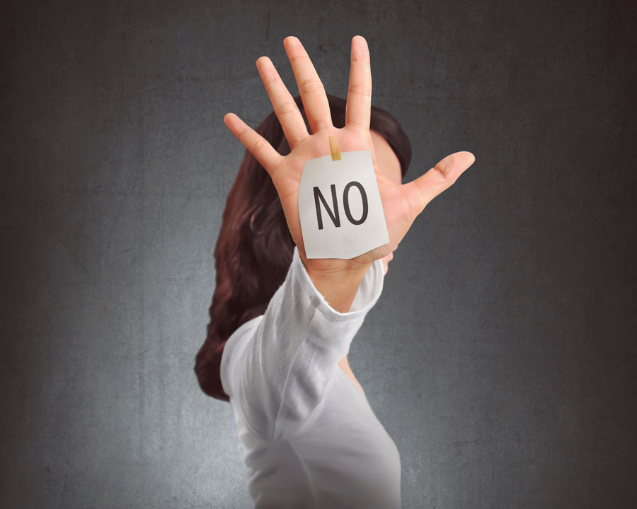 Saying No in Plastic Surgery Side view of a woman showing NO note on her hand